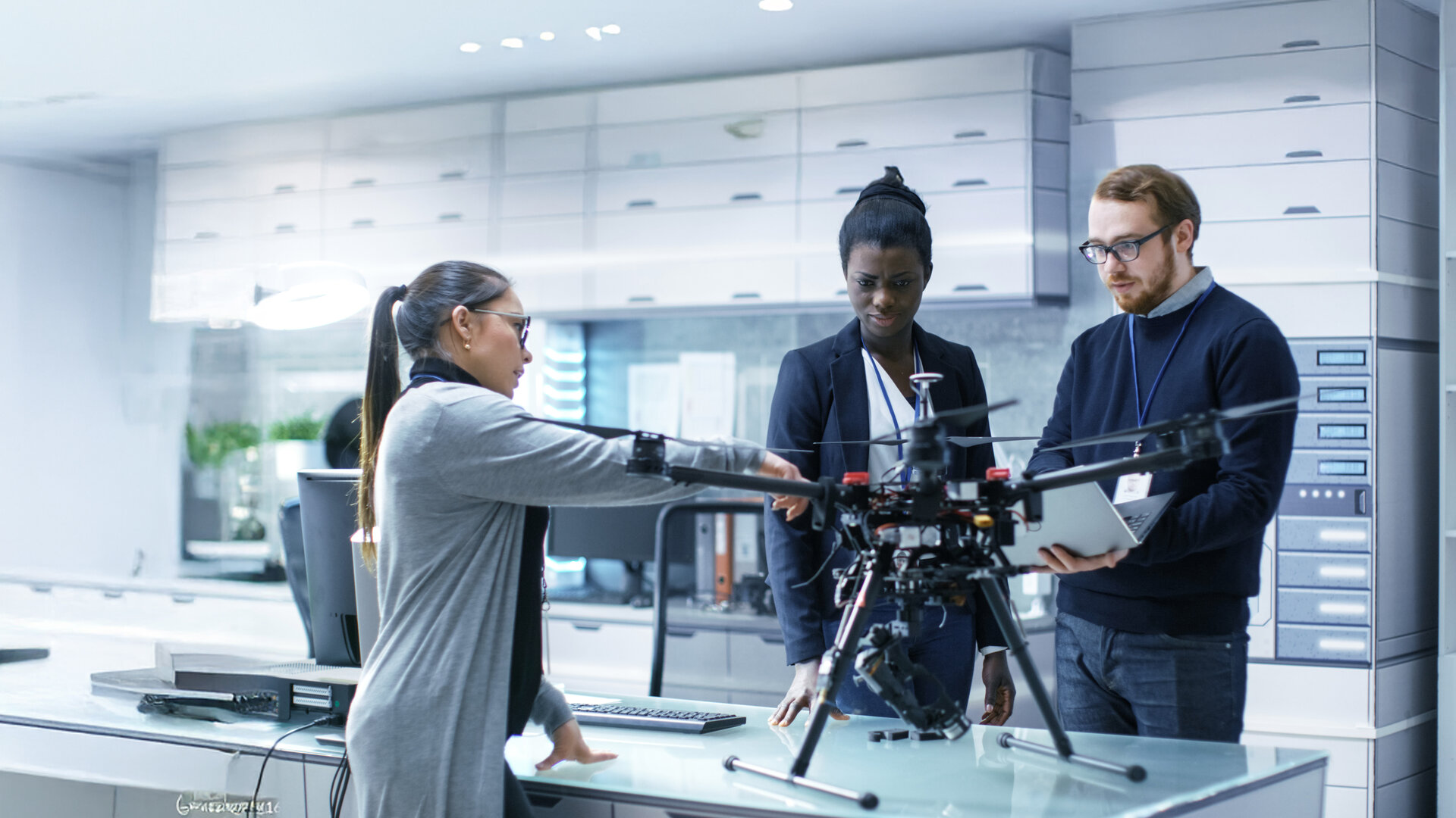 people in a clean room working on a drone
